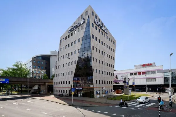 Hoekpand van de Rabobank aan de Twentestraat met op de achtergrond het winkelcentrum Zuidplein en HEMA in Rotterdam.