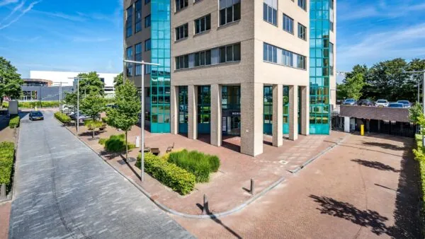 Kantoorgebouw aan de Overschieseweg met moderne gevel en glazen elementen, gezien vanaf straatniveau.