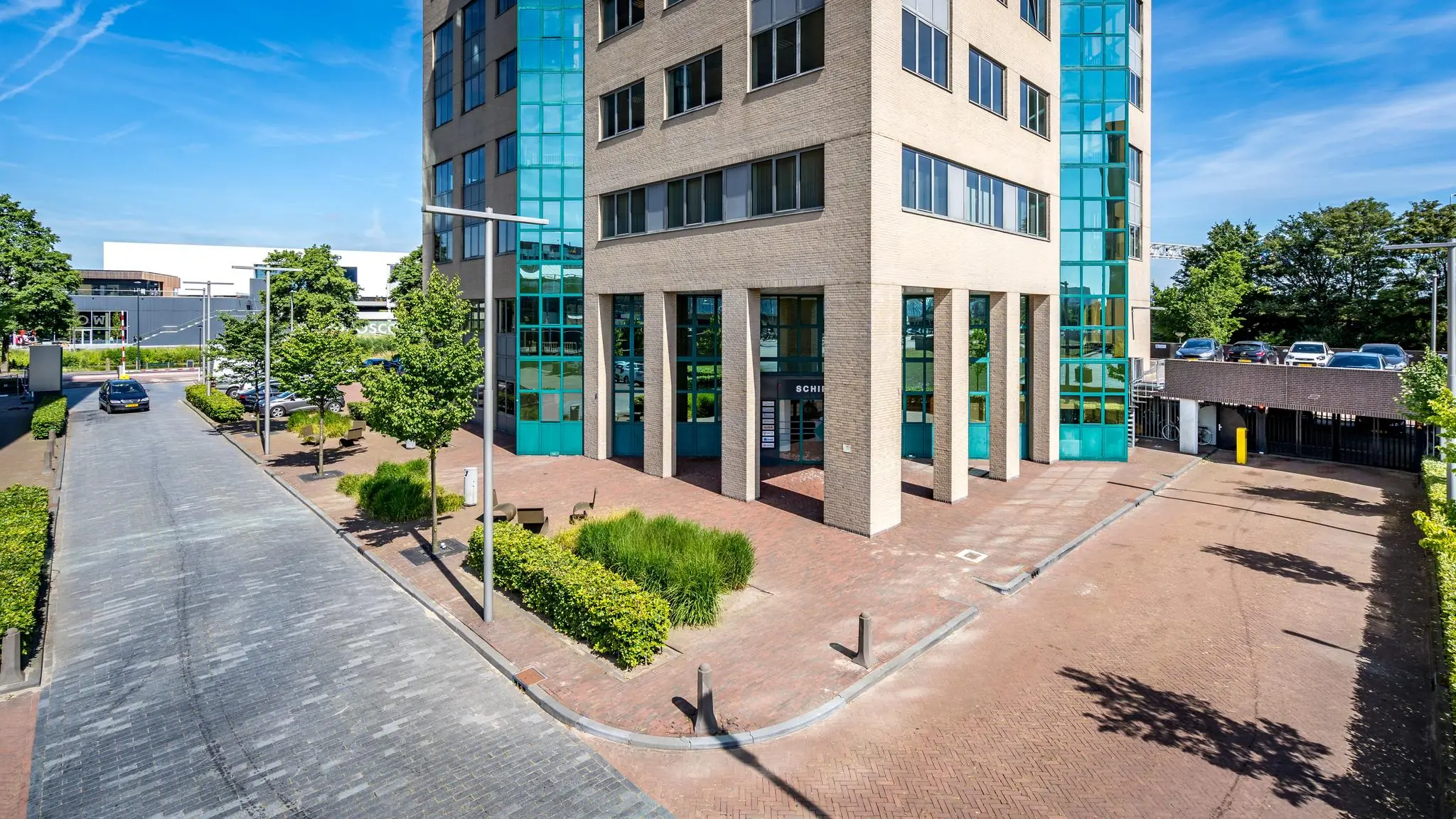 Kantoorgebouw aan de Overschieseweg met moderne gevel en glazen elementen, gezien vanaf straatniveau.