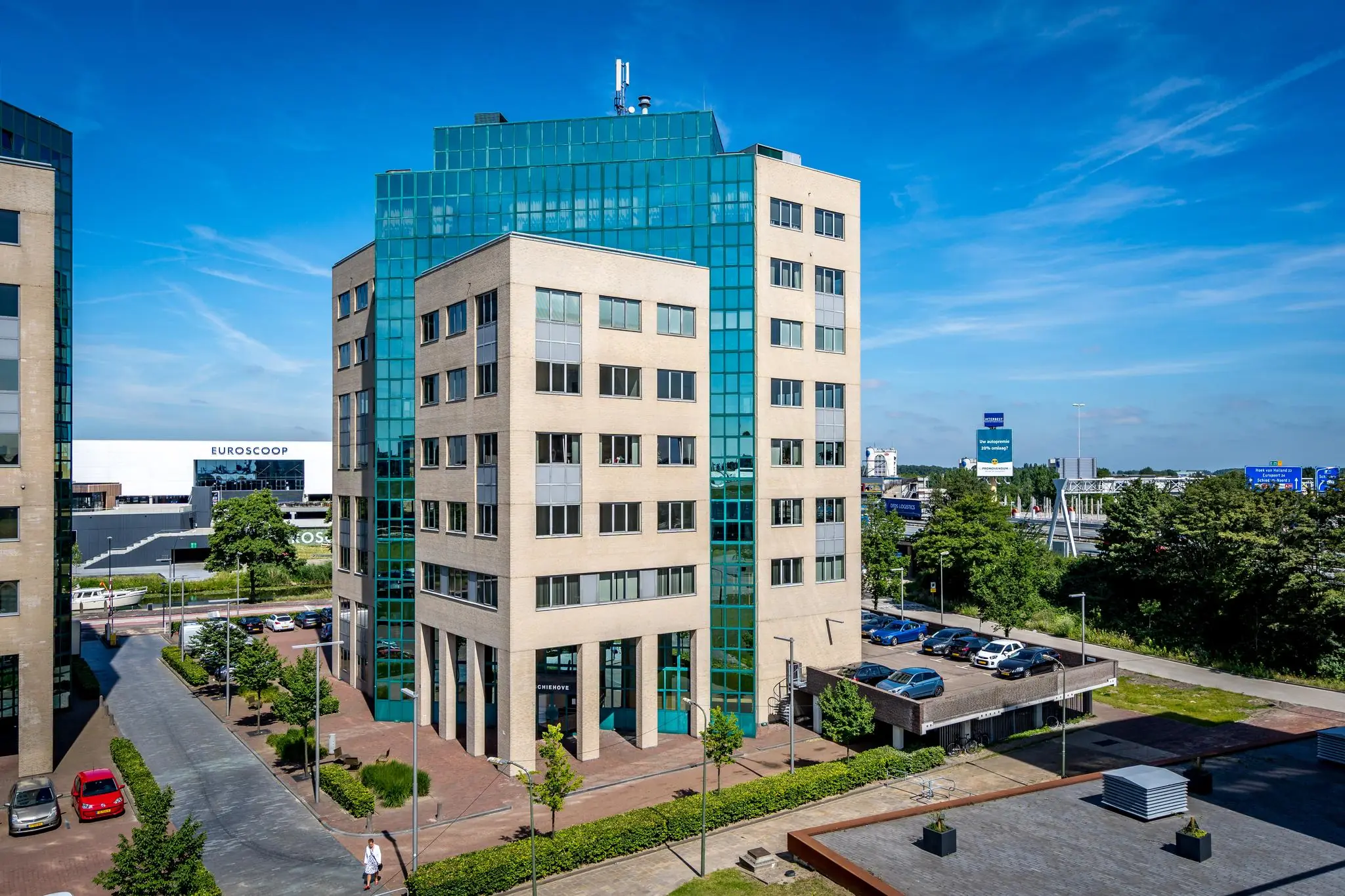 Kantoorgebouw aan de Overschieseweg in Rotterdam met moderne gevel en parkeergelegenheid op een zonnige dag.