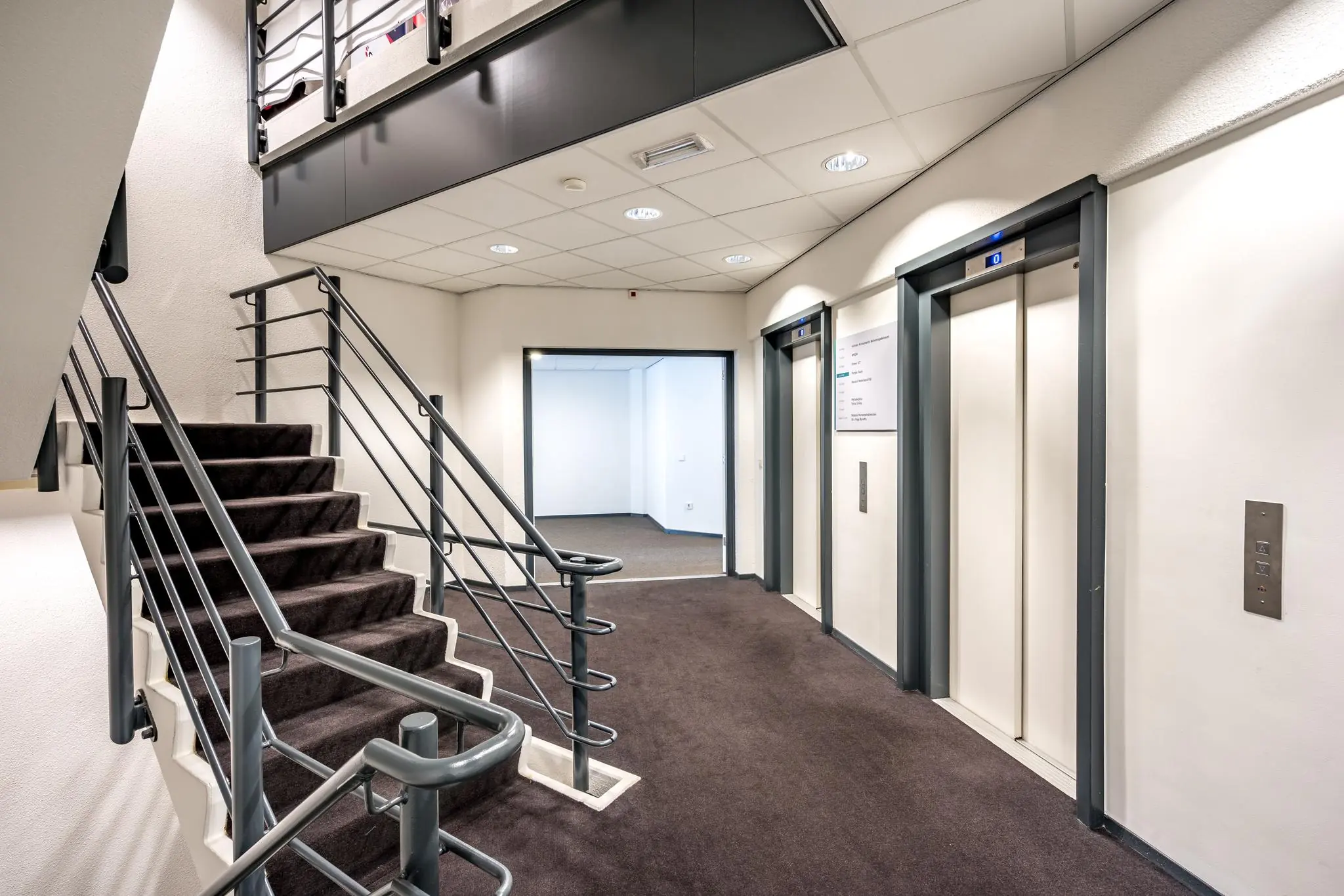 Modern trappenhuis met twee liften in een kantoorgebouw aan de Overschieseweg.