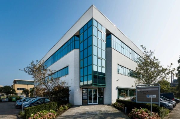Modern kantoorgebouw aan de Zekeringstraat 41 met grote glazen gevel en omringende parkeerplaatsen.