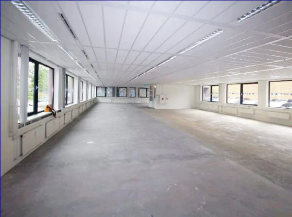 Leeg en ruim kantoorpand aan het Stationsplein met grote ramen en systeemplafond.