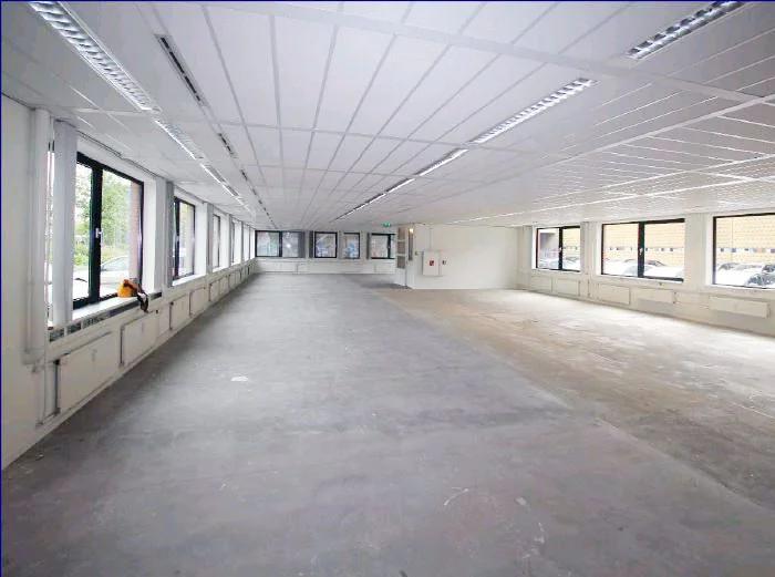 Leeg en ruim kantoorpand aan het Stationsplein met grote ramen en systeemplafond.