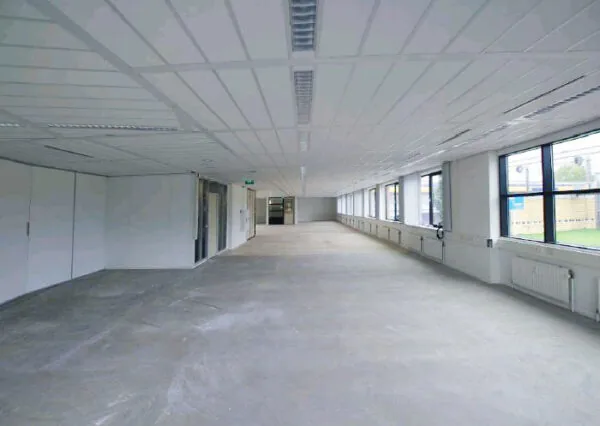 Leegstaand kantoorpand aan het Stationsplein met grote ramen en systeemplafond.