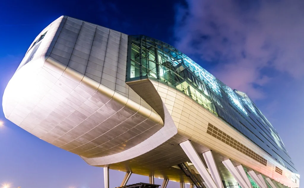 Modern kantoorgebouw aan de Amstelveenseweg in Amsterdam in de avond, met opvallende futuristische architectuur en verlichting.