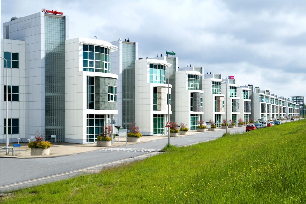 Moderne kantoorgebouwen aan het Rhijnspoor met opvallende gevels en parkeergelegenheid langs de weg.