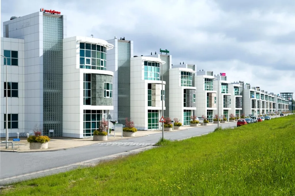 Moderne kantoorgebouwen aan het Rhijnspoor met opvallende gevels en parkeergelegenheid langs de weg.