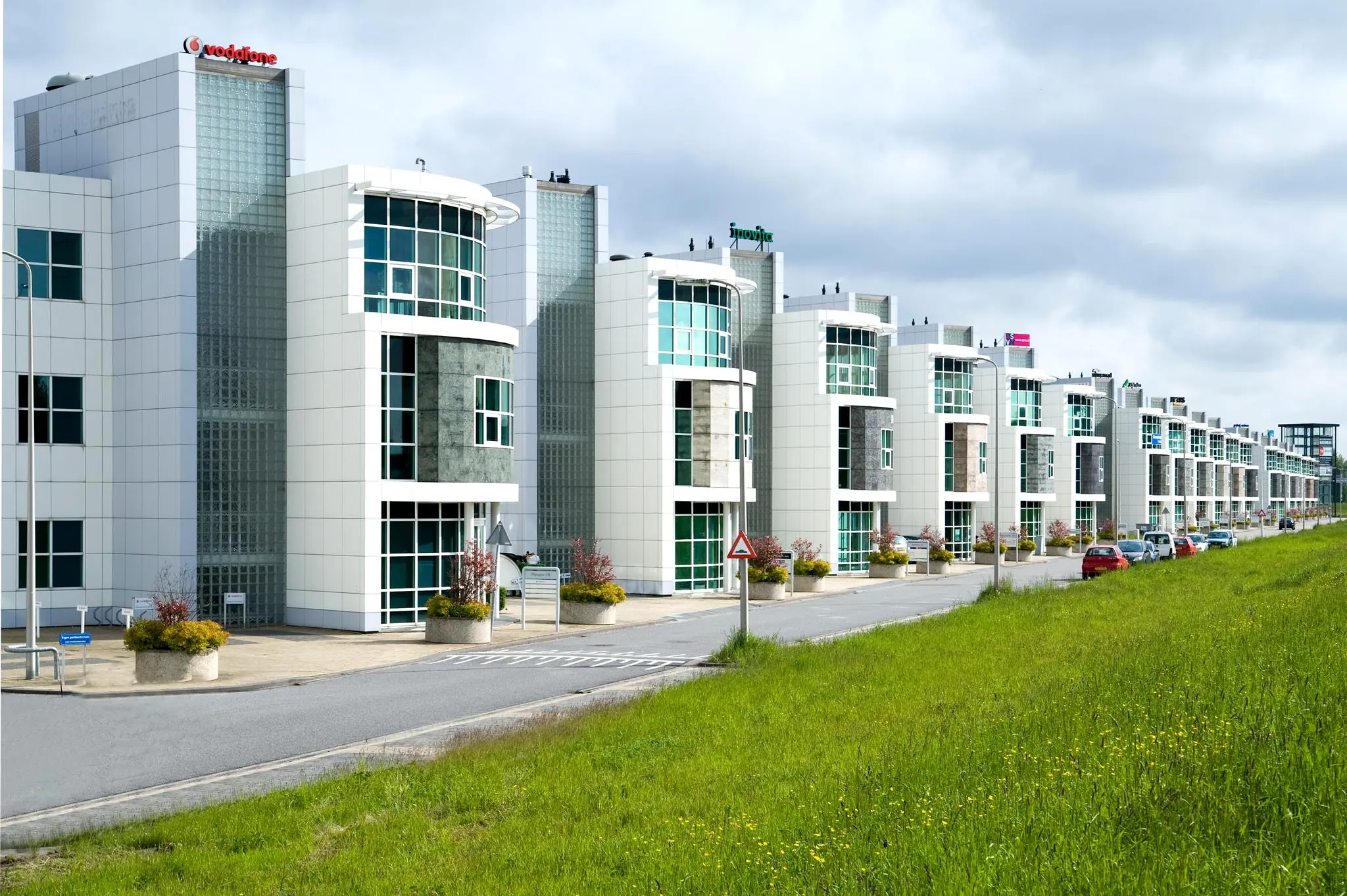 Moderne kantoorgebouwen aan het Rhijnspoor met opvallende gevels en parkeergelegenheid langs de weg.