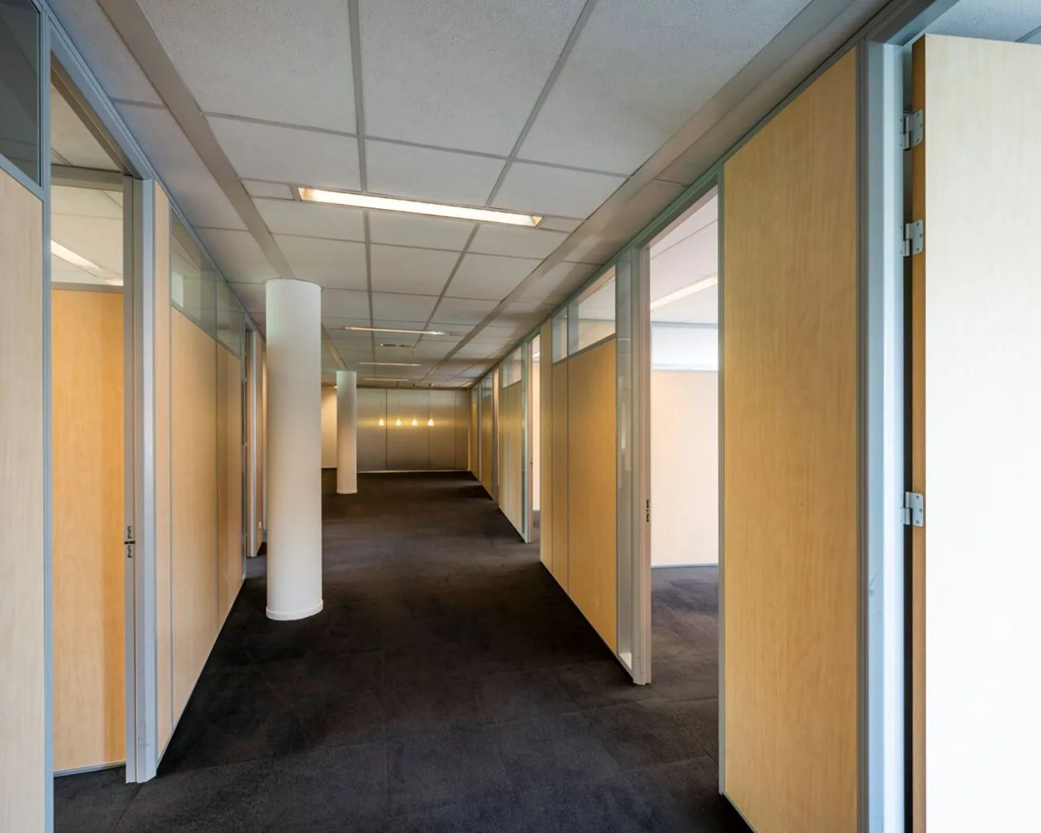 Gang met meerdere kantoorruimtes in Entrada 300 in Amsterdam, met houten deuren en systeemplafond.