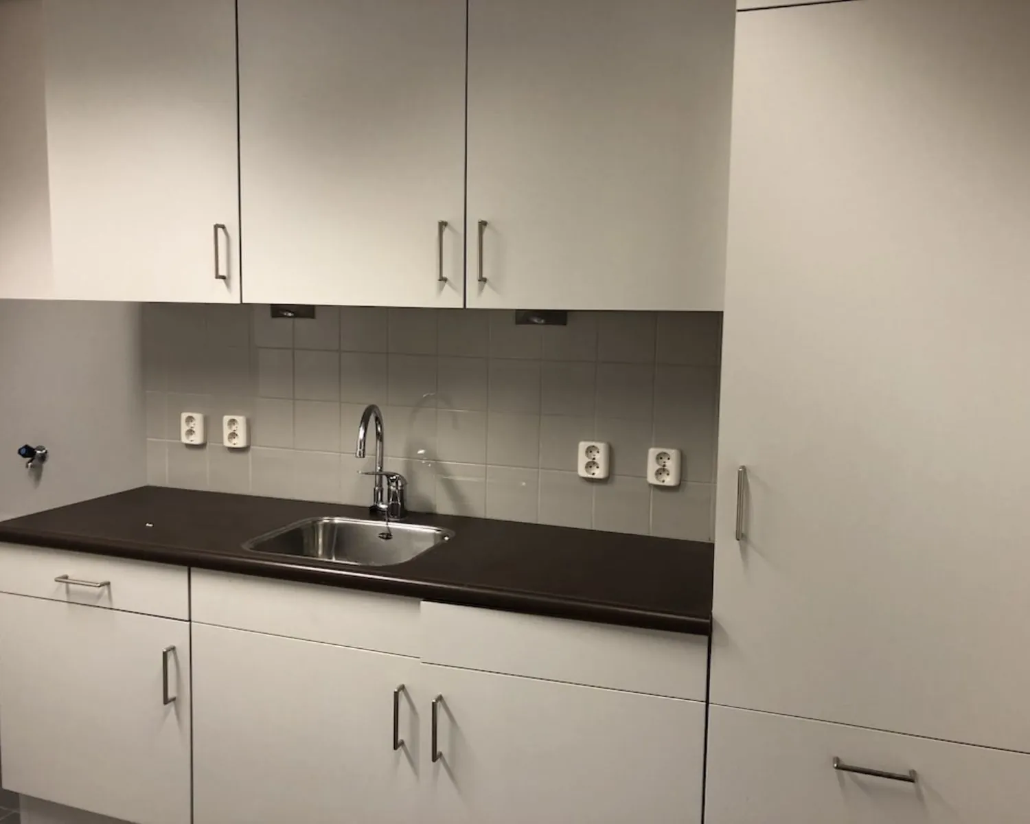 Keukenblok met witte kasten, spoelbak en stopcontacten in een kantoorruimte aan de Hooilaan 1 in Breda.
