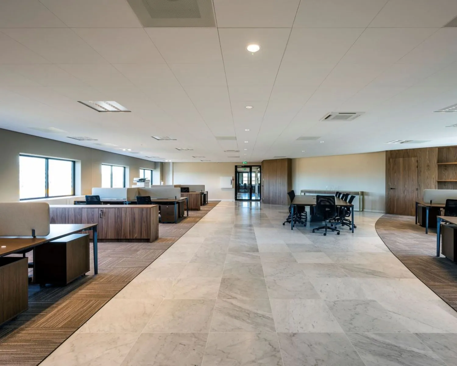 Ruime, moderne kantoorruimte met werkplekken en vergadertafels aan de Wegalaan 35 in Hoofddorp.