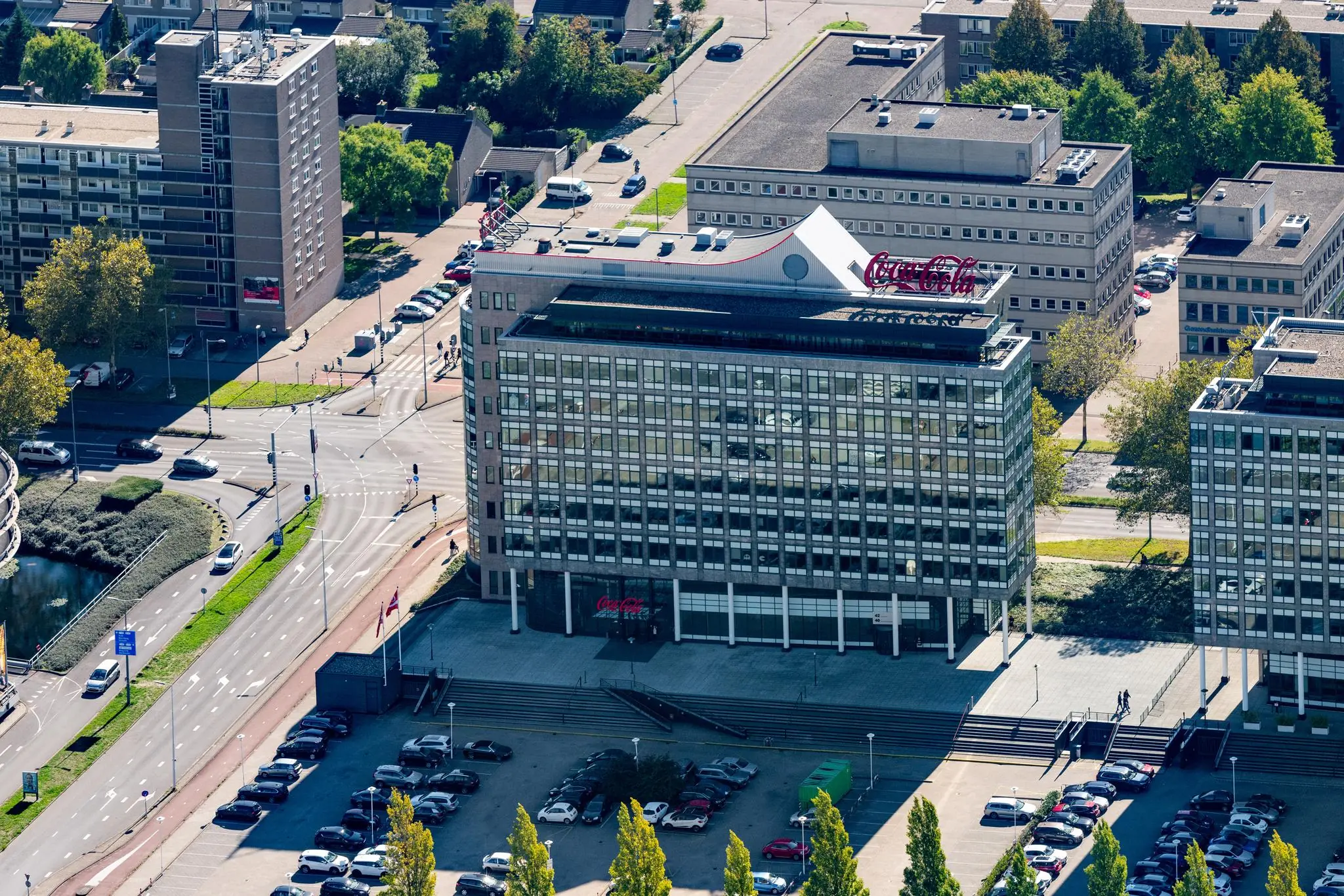 Luchtfoto van een kantoorgebouw aan de Watermanweg in Rotterdam met een Coca-Cola logo op het dak.