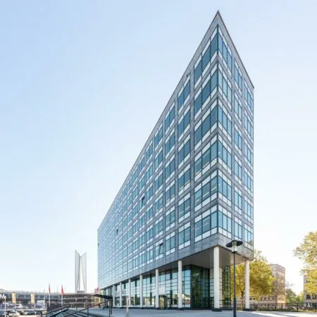 Moderne kantoorgebouw aan de Watermanweg in Rotterdam met glazen gevel en opvallende driehoekige vorm.