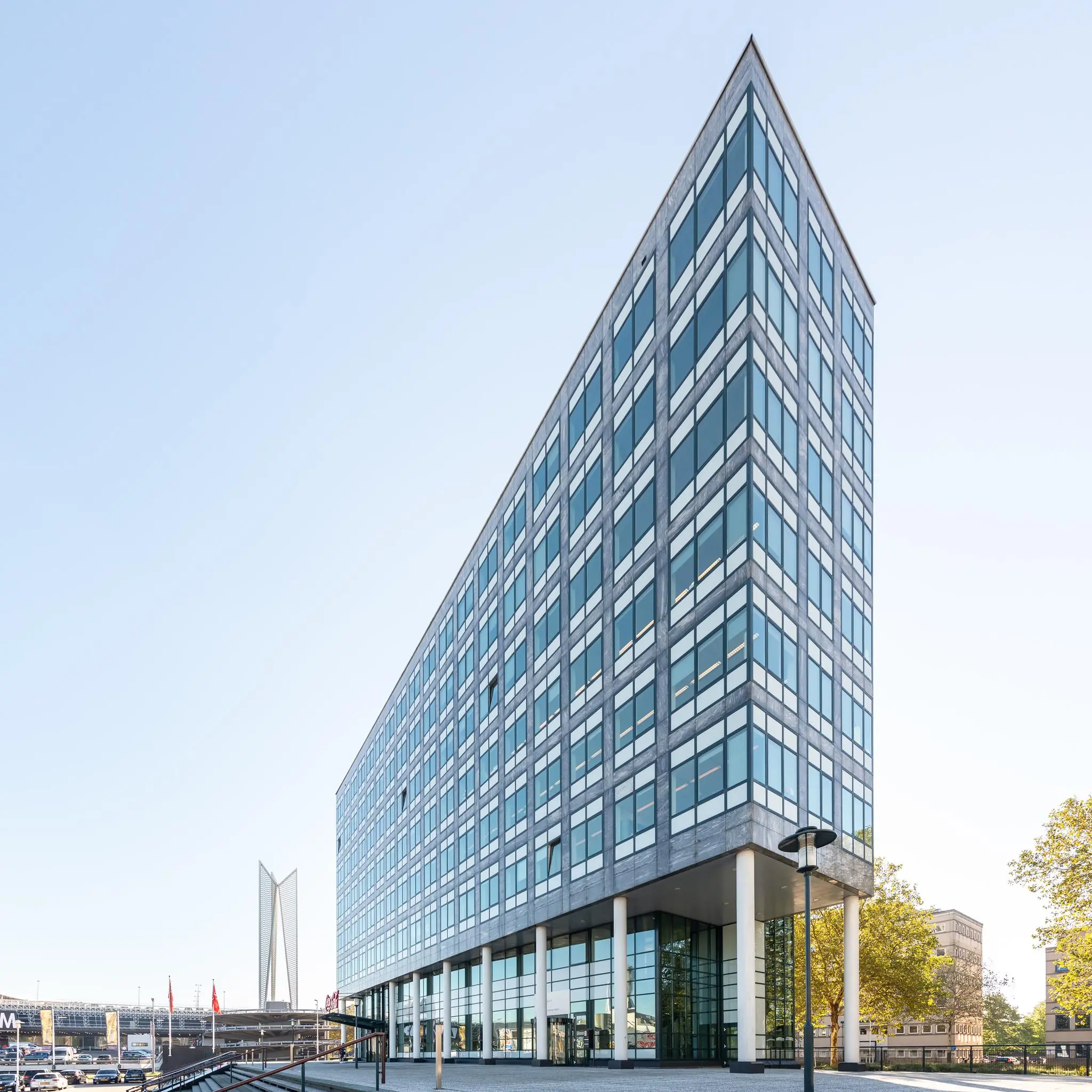 Moderne kantoorgebouw aan de Watermanweg in Rotterdam met glazen gevel en opvallende driehoekige vorm.