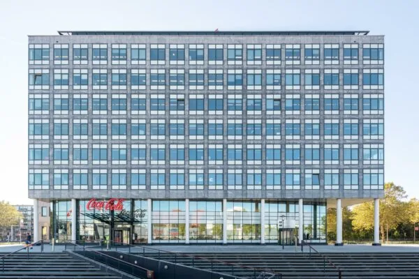 Vooraanzicht van een modern kantoorgebouw aan de Watermanweg met een Coca-Cola-logo boven de ingang.