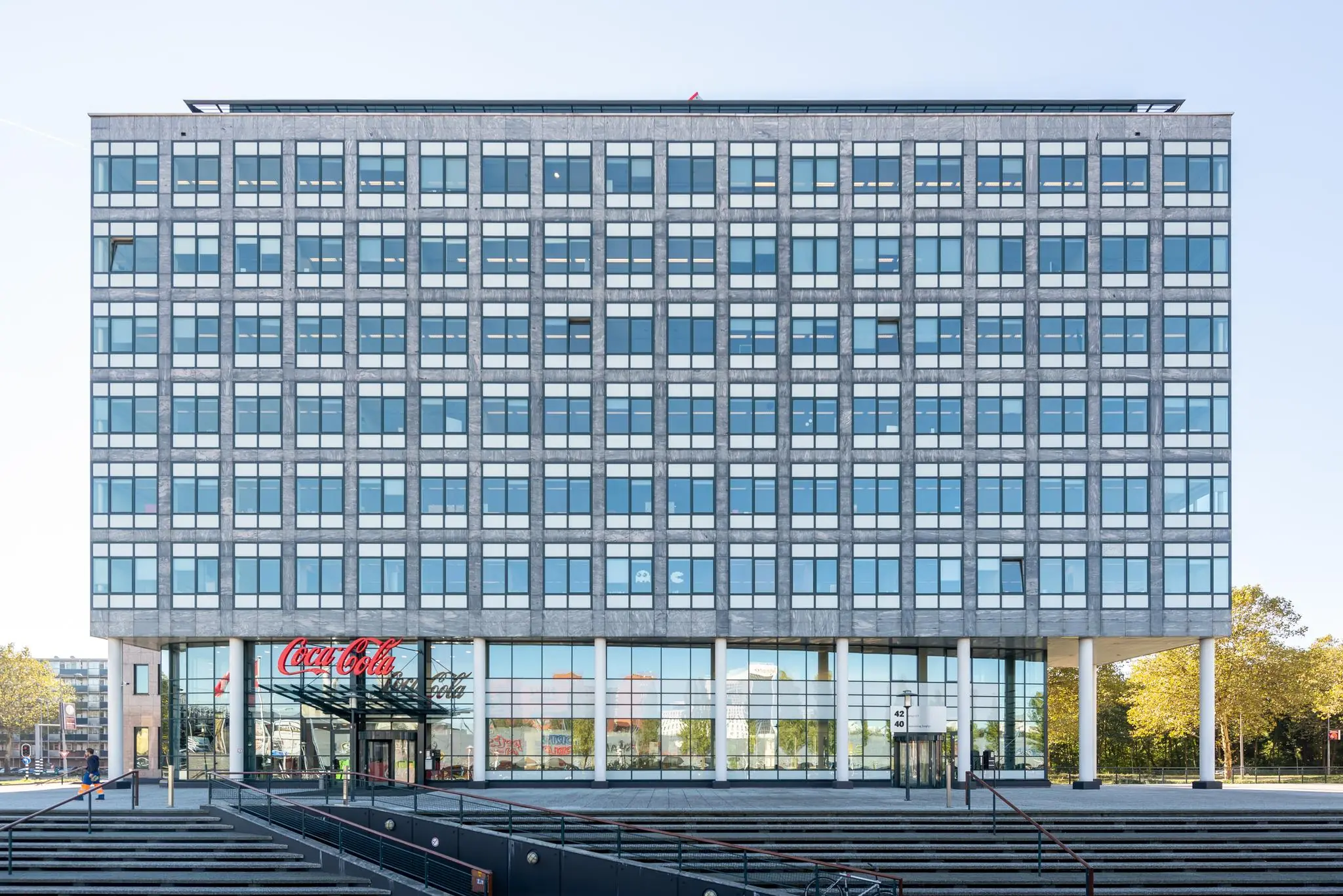 Vooraanzicht van een modern kantoorgebouw aan de Watermanweg met een Coca-Cola-logo boven de ingang.