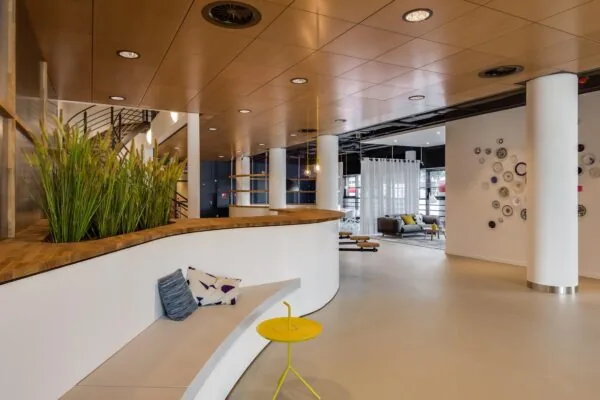 Modern interieur van een kantoorruimte aan het Willemsplein met zithoek, houten plafond en decoratieve wand met borden.