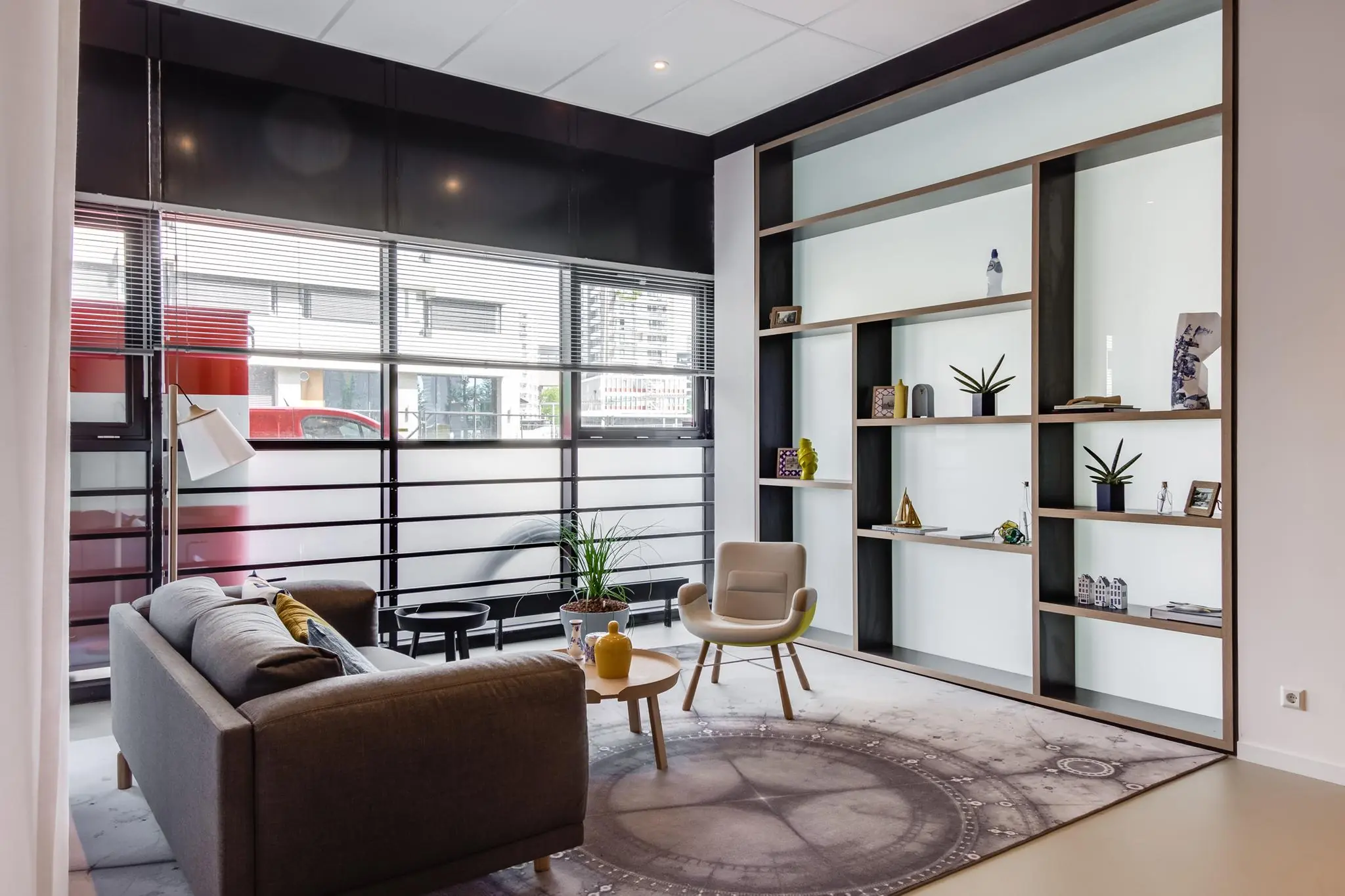 Modern ingerichte zithoek aan het Willemsplein met een grote wandkast, designmeubels en veel daglicht.