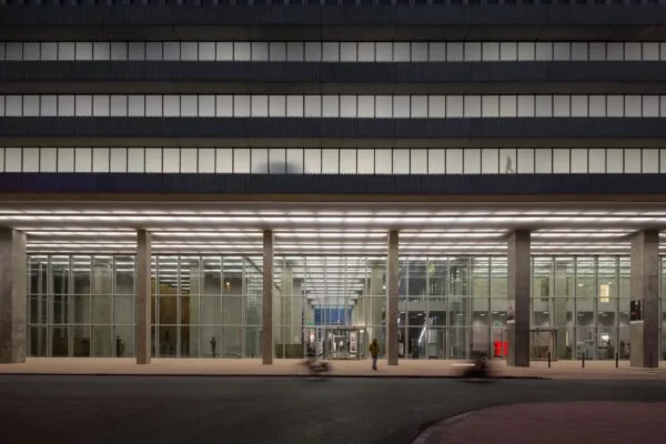 Modern glazen kantoorgebouw aan de Wilhelminakade in Rotterdam, gefotografeerd in de avond.