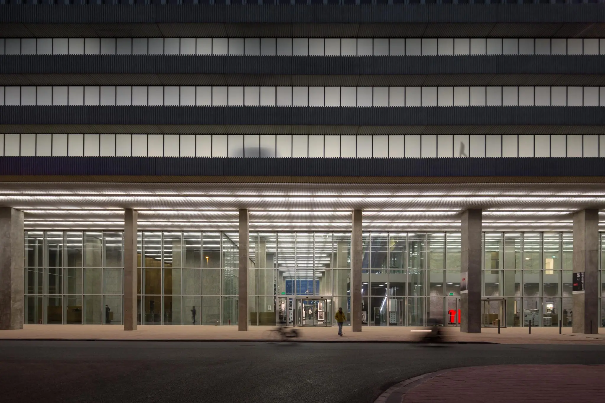 Modern glazen kantoorgebouw aan de Wilhelminakade in Rotterdam, gefotografeerd in de avond.