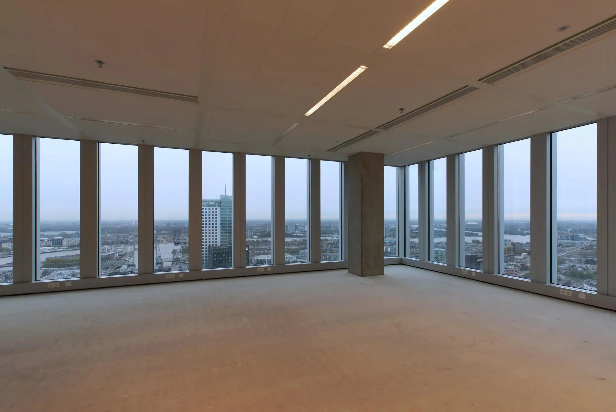 Leeg kantoorpand met panoramisch uitzicht over Rotterdam vanaf de Wilhelminakade.