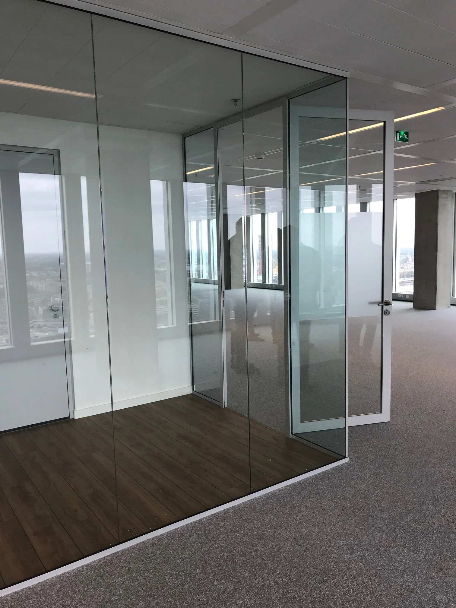 Moderne kantoorruimte op de Wilhelminakade met glazen wanden en uitzicht over de stad.