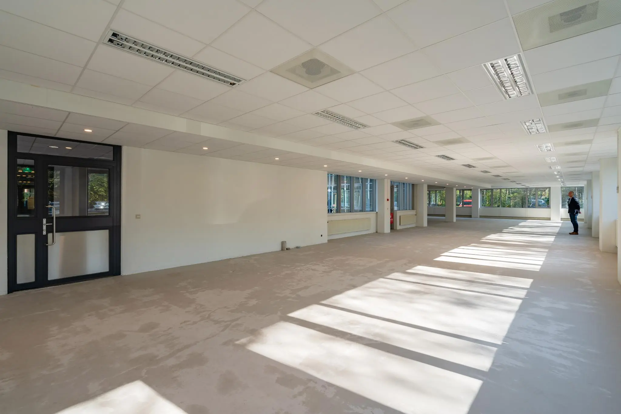 Lichte, lege kantoorruimte aan de Utrechtseweg met grote ramen en systeemplafond.