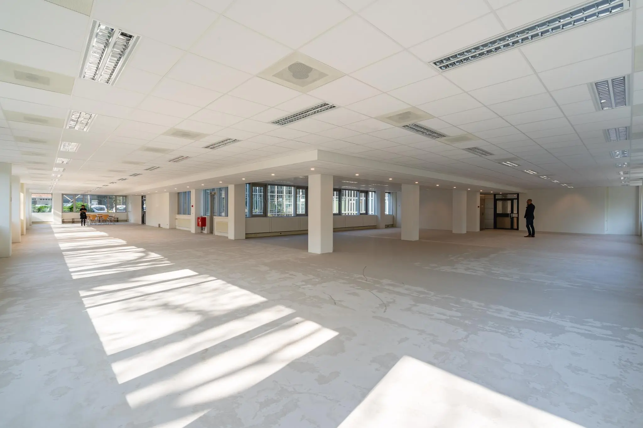 Lichte, lege kantoorruimte aan de Utrechtseweg met grote ramen en systeemplafond.