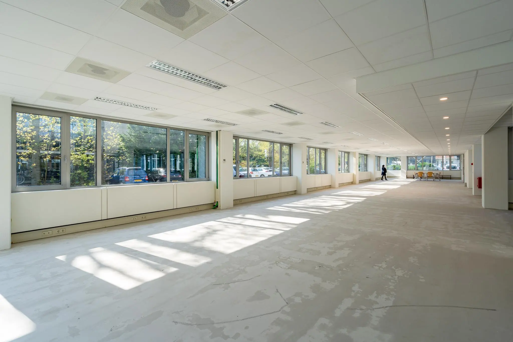Lichte, lege kantoorruimte aan de Utrechtseweg met grote ramen en systeemplafond.