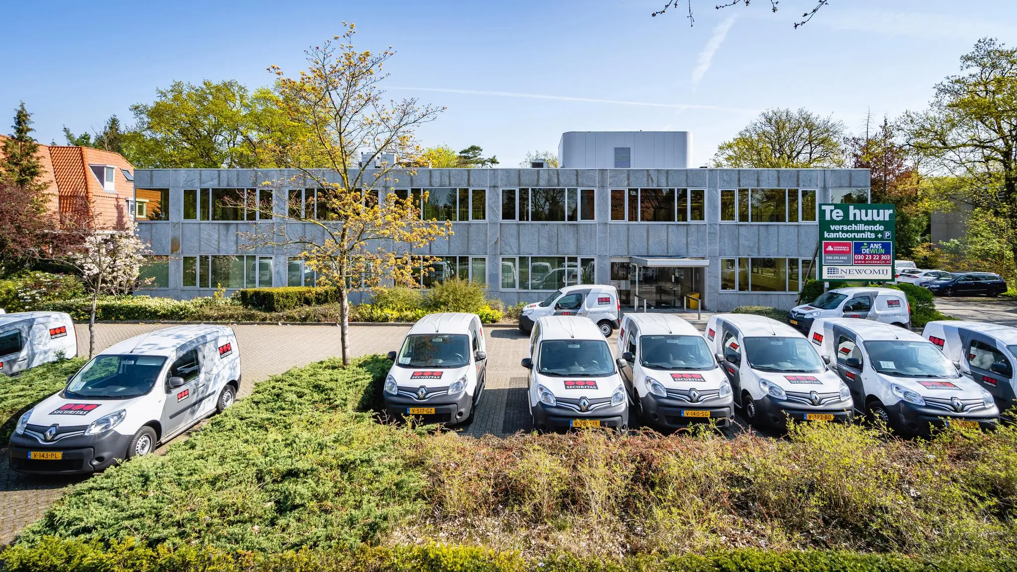 Bedrijfsgebouw aan de Utrechtseweg met meerdere bestelbussen van Schipper Kozijnen geparkeerd op de voorgrond.