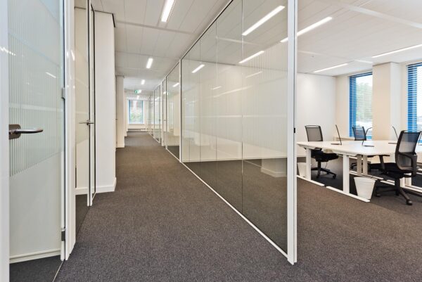 Moderne kantoorruimte aan de Kosterijland met glazen wanden, bureaus en ergonomische stoelen.
