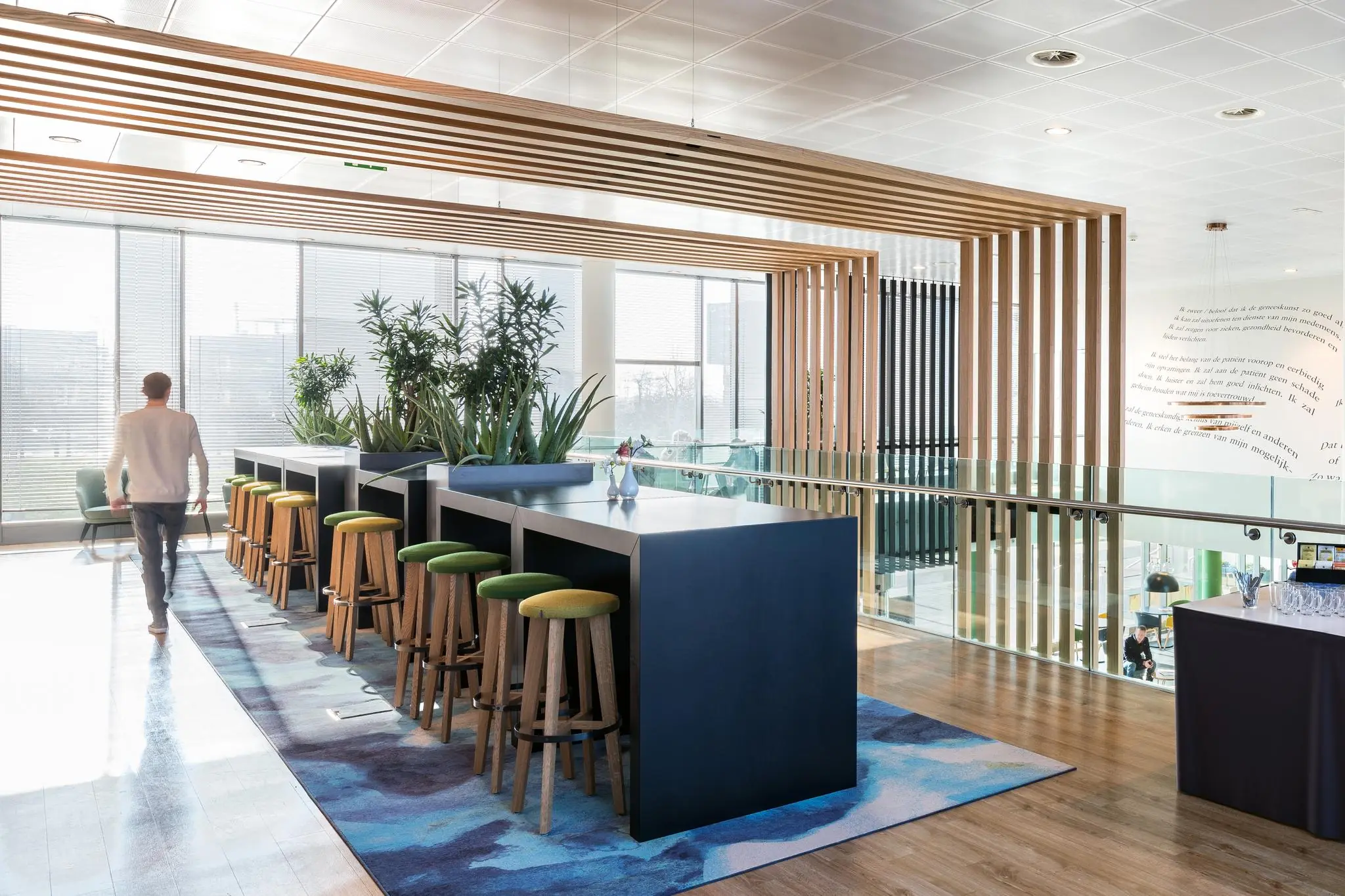 Moderne kantoorruimte aan de Mercatorlaan met hoge tafels, krukken, planten en veel daglicht.