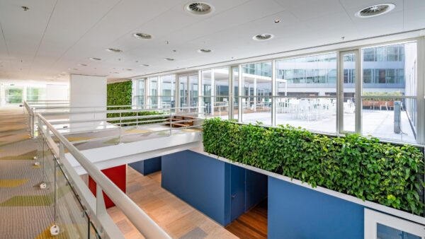 Modern kantoorinterieur aan de Newtonlaan met veel glas, groenwanden en uitzicht op een binnenterras.
