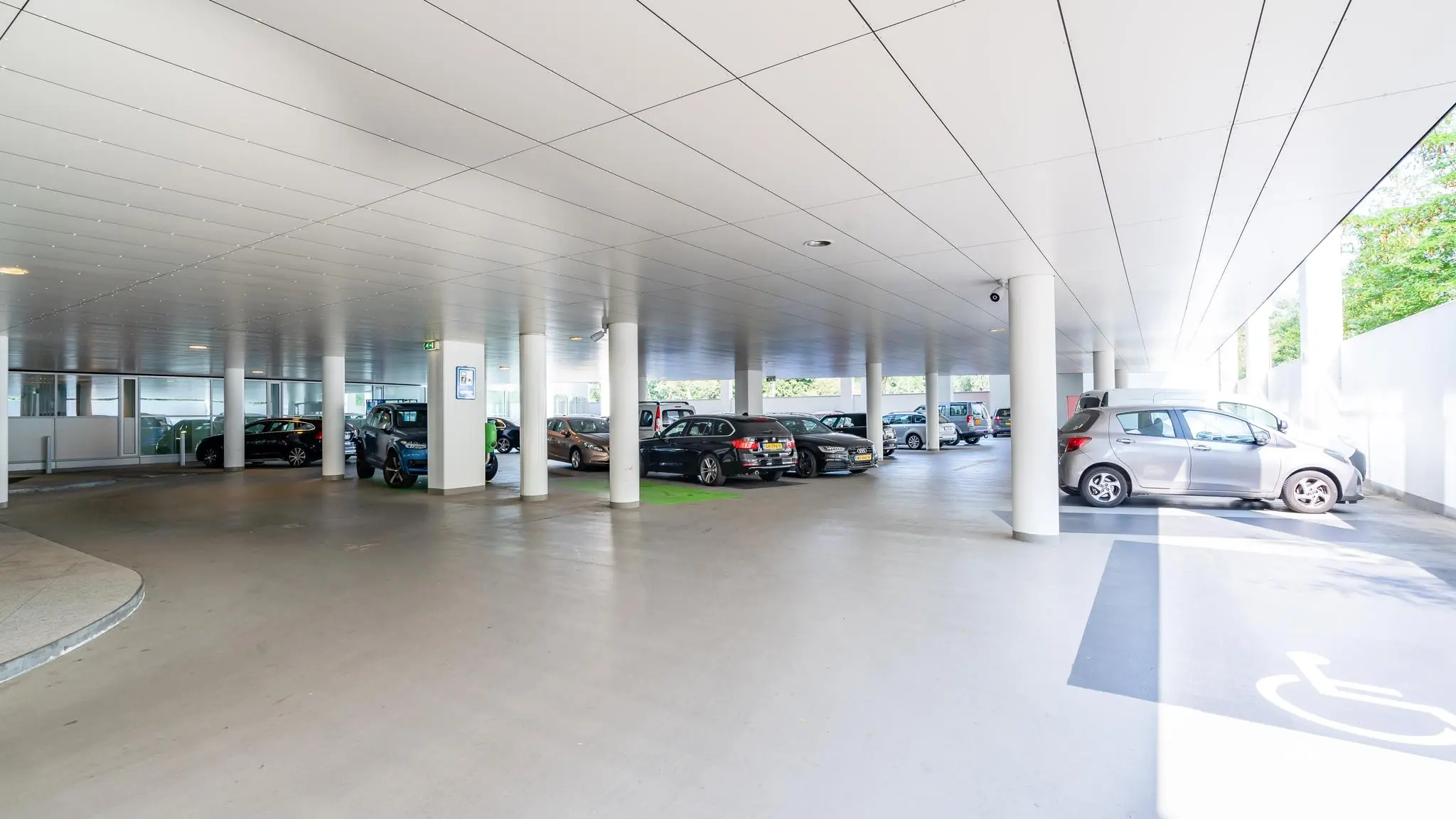 Overdekte parkeergarage aan de Newtonlaan met meerdere geparkeerde auto's en een invalidenparkeerplaats op de voorgrond.