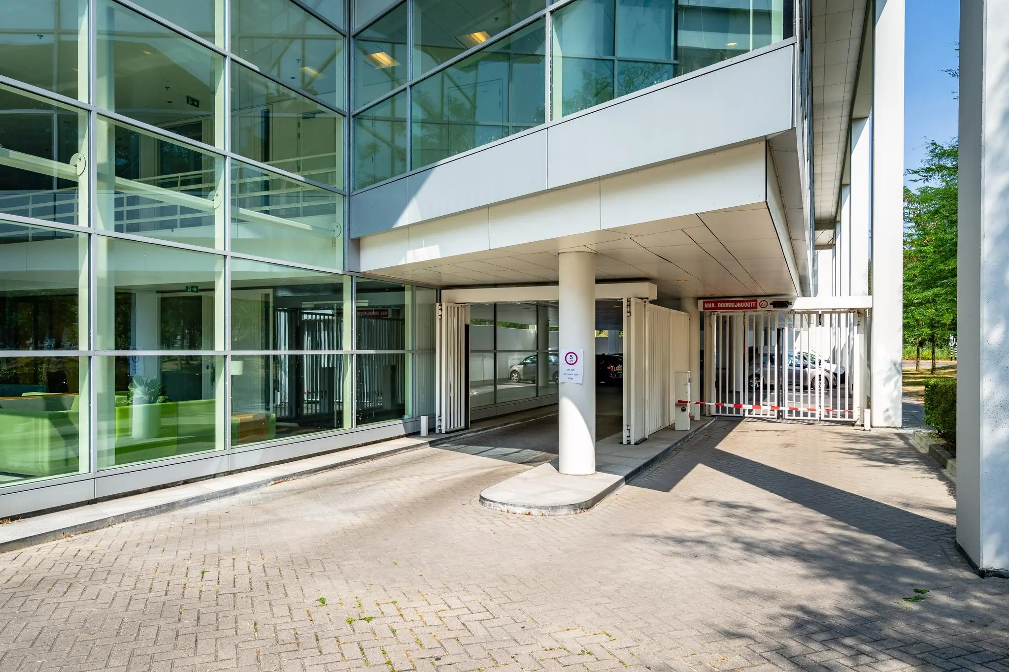 Ingang van een overdekte parkeergarage bij een modern kantoorgebouw aan de Newtonlaan.