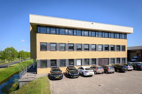 Modern kantoorgebouw aan de Spoorhaven met parkeergelegenheid en aangrenzend water.