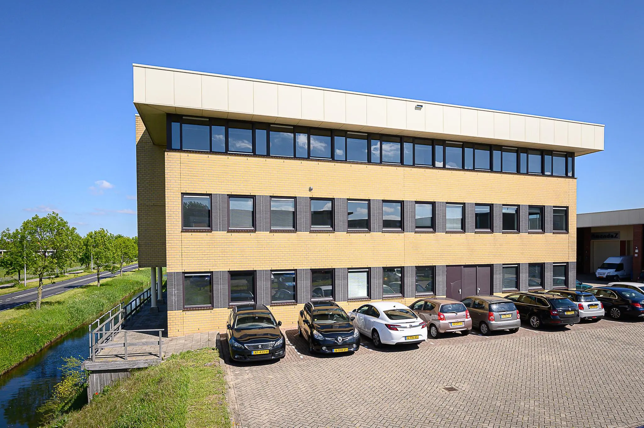 Modern kantoorgebouw aan de Spoorhaven met parkeergelegenheid en aangrenzend water.