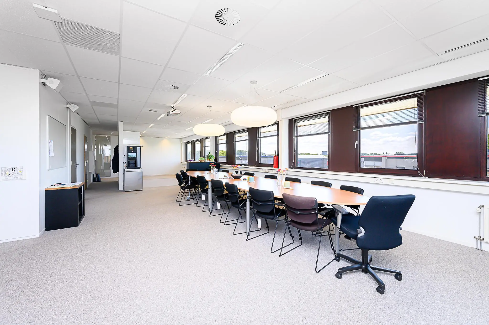 Vergaderruimte in een modern kantoor aan de Spoorhaven met lange tafel, stoelen en grote ramen.