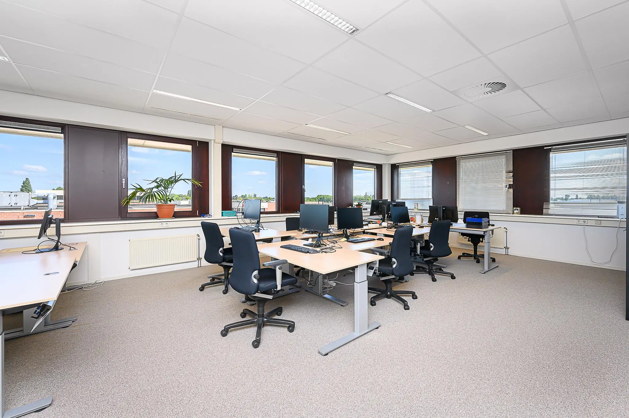 Ruime en lichte kantoortuin aan de Spoorhaven met meerdere werkplekken en computers.