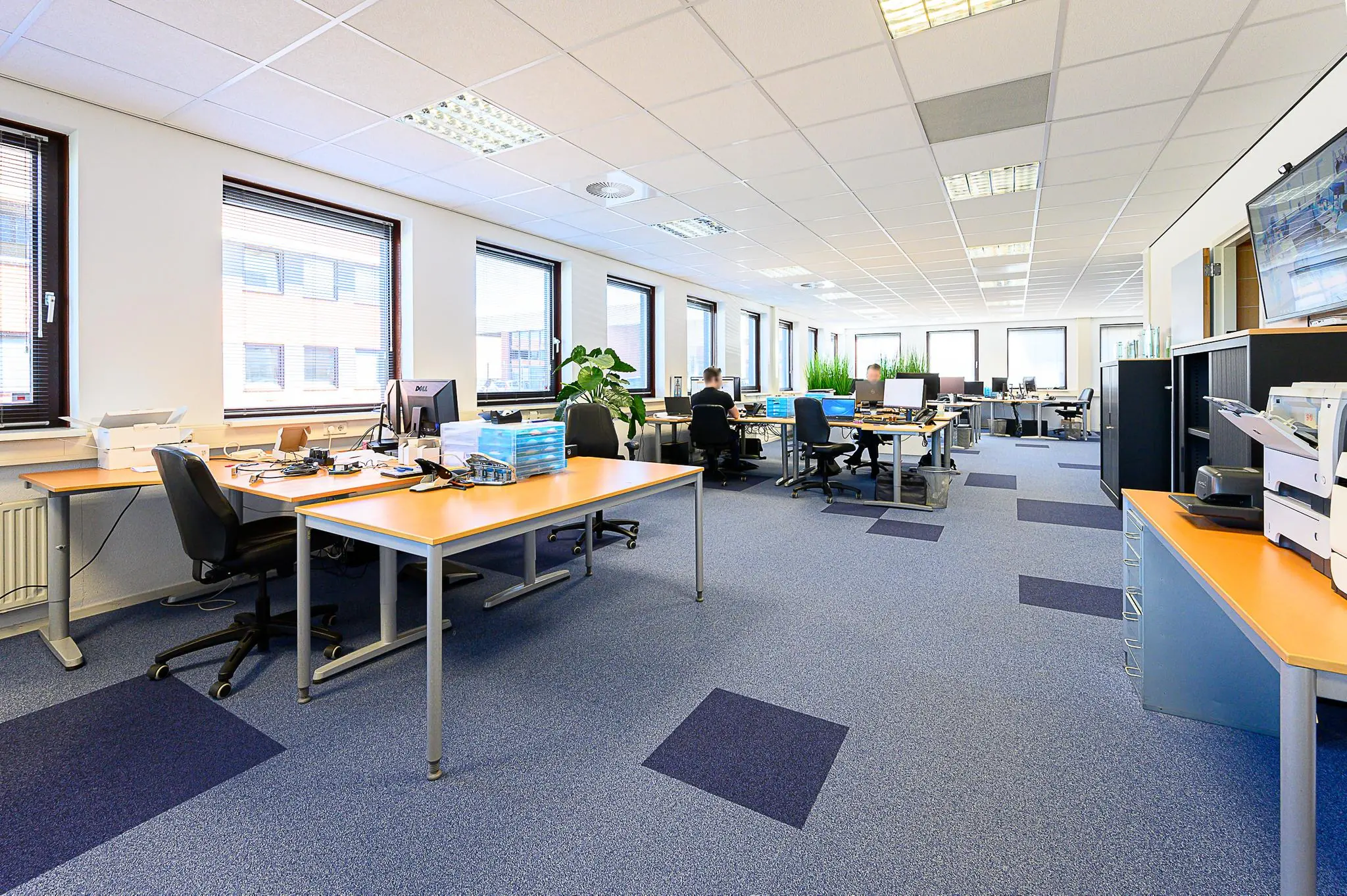 Ruim, licht kantoor in Spoorhaven met meerdere werkplekken, computers en grote ramen.