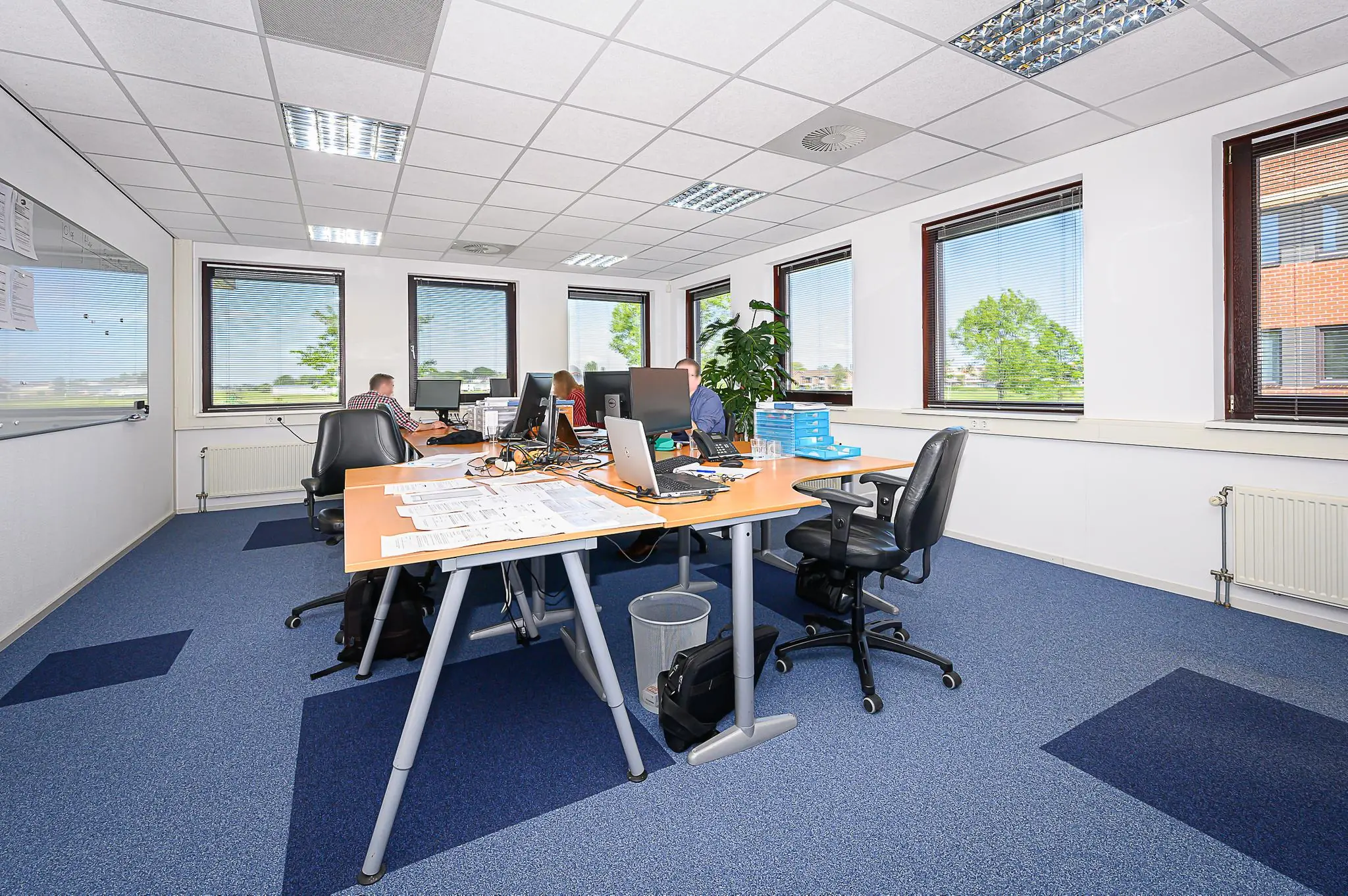 Moderne kantoorruimte in Spoorhaven met bureaus, computers en werkende medewerkers.