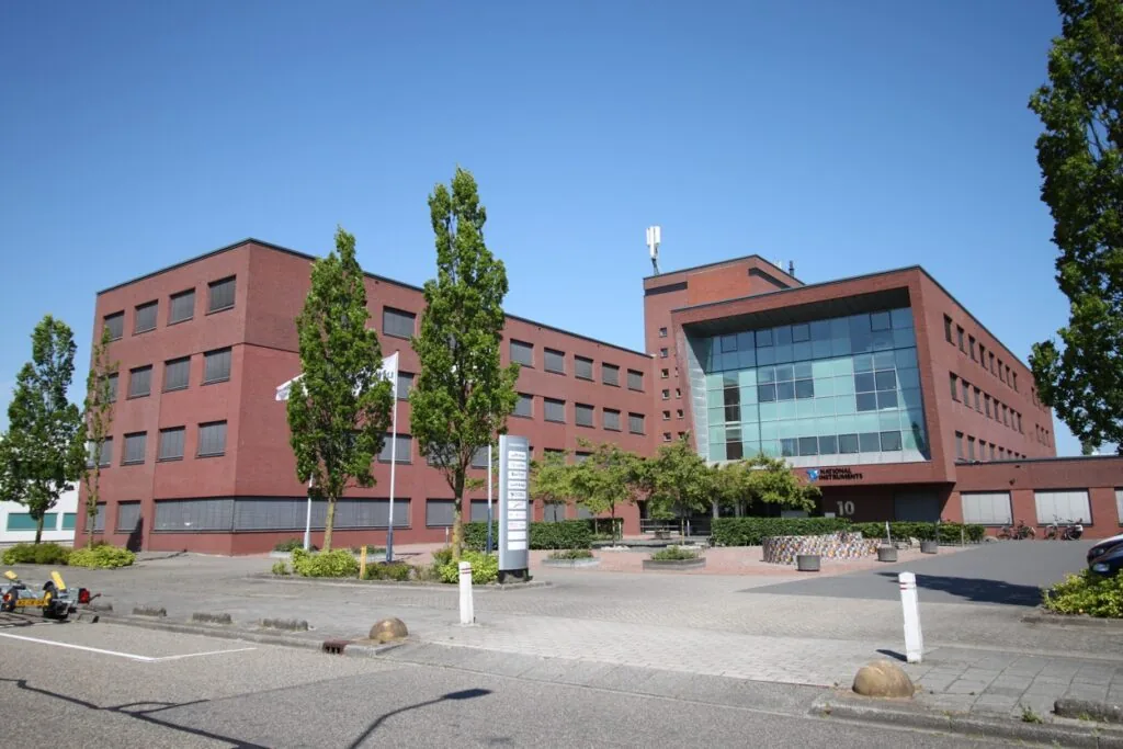 Kantoorgebouw aan de Pompmolenlaan 10 in een moderne rode bakstenen stijl met het logo van National Instruments op de gevel.