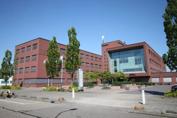 Kantoorgebouw aan de Pompmolenlaan 10 in een moderne rode bakstenen stijl met het logo van National Instruments op de gevel.