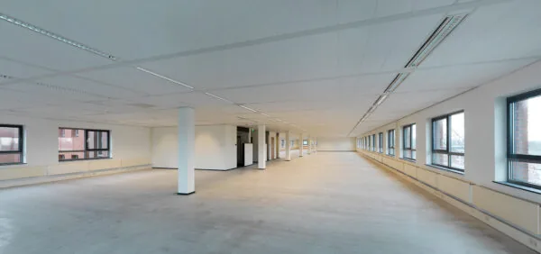 Leeg en ruim kantoorinterieur aan de Pompmolenlaan met grote ramen en systeemplafond.