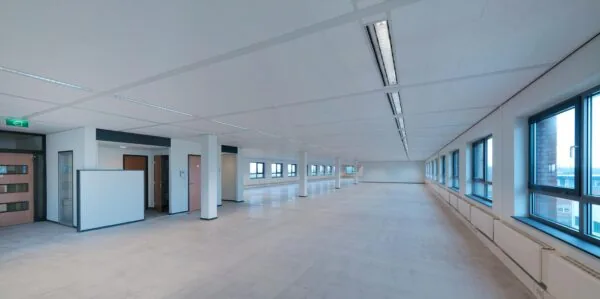 Leeg en modern kantoorruimte-interieur aan de Pompmolenlaan met grote ramen en systeemplafond.