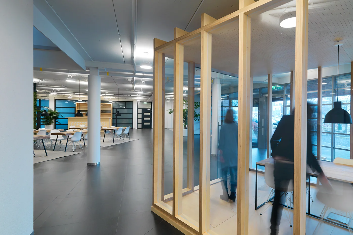 Moderne kantoorlobby aan de Pompmolenlaan met glazen vergaderruimte en open zitgedeelte.