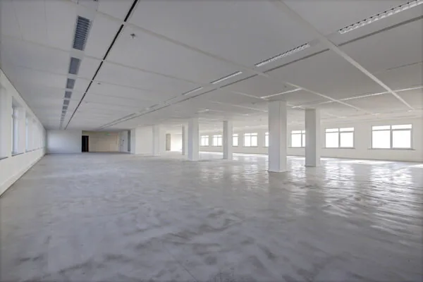 Leeg en ruim kantoorgebouw aan de Winthontlaan met betonnen vloer en grote ramen.