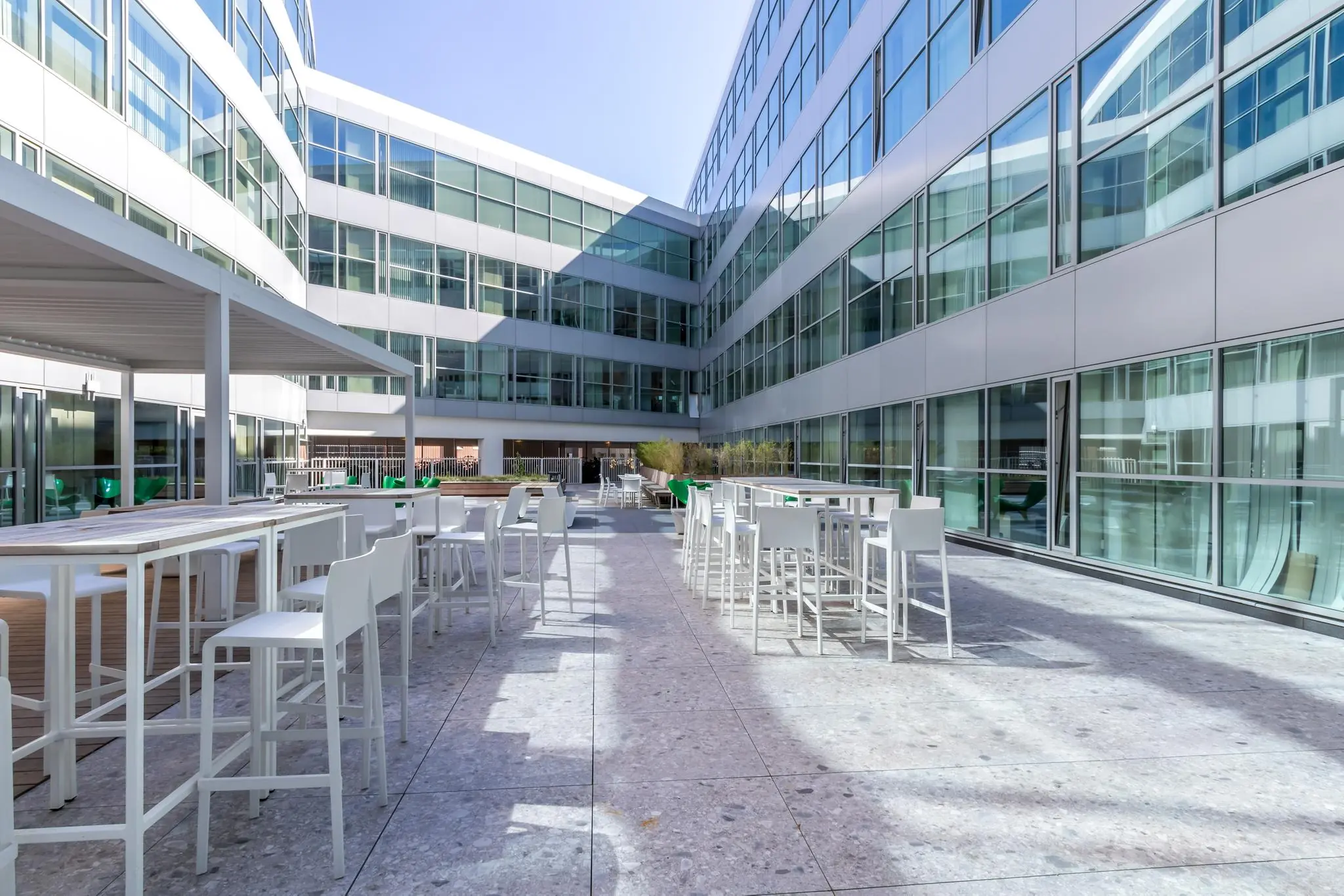 Zonnig dakterras met moderne witte zitplaatsen bij het kantoorpand aan de Newtonlaan.