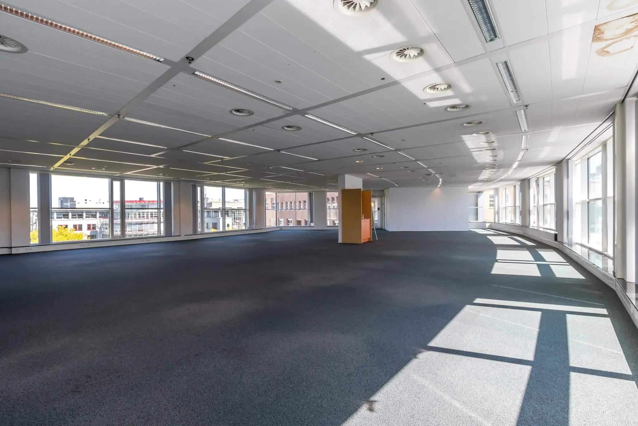 Licht en ruim leeg kantoorpand aan de Newtonlaan met grote ramen en systeemplafond.